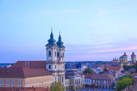 少数民族教堂的美丽的看法和 Eger, 匈牙利的城市全景, 在日落