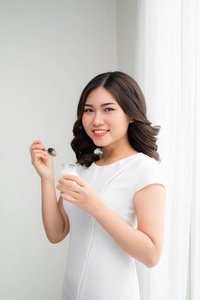 饮食特写肖像一个有魅力的年轻女人吃酸奶