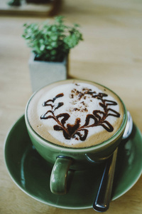 热摩卡一杯咖啡与美丽的拿铁艺术在木桌背景, 早早餐