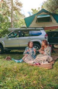 妇女坐在毯子下与 4 x 4 的背景