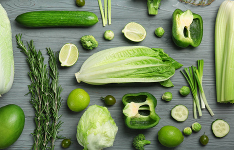 在木质背景下, 用绿色蔬菜和水果平躺在一起.食品摄影照片