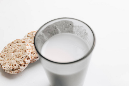 脆面包和牛奶的玻璃被隔离在白色背景, 健康早餐