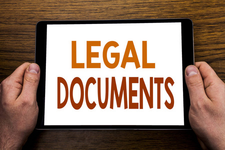 手写文字标题法律文件。在平板电脑上写的合同文件的业务概念, 木制背景与商人手, 手指持有 Pc