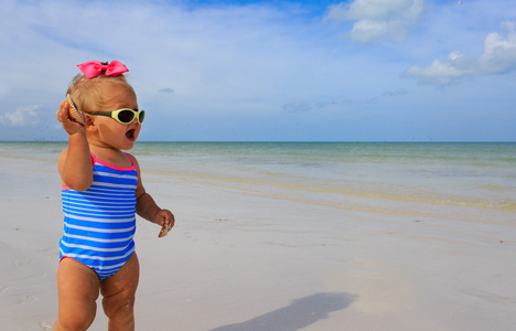 可爱的小女孩，在沙滩上玩贝壳