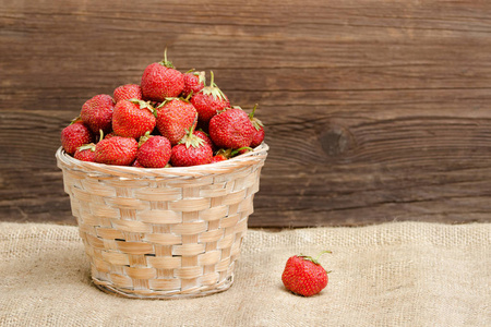 一篮子成熟的草莓在麻布。文本空间