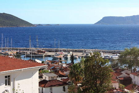 海滩上有红色瓷砖屋顶的地中海城镇。游艇