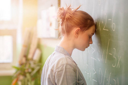 数学课上的那个十几岁的女孩被数学公式淹没了。压力教育成功理念