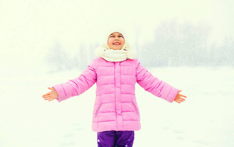 冬天快乐微笑女孩小孩子喜欢雪花在雪中