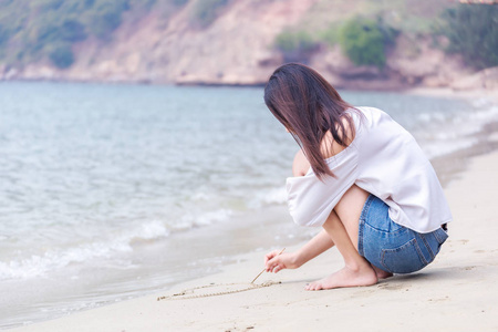 在沙滩上写着沙子的女人