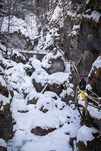 年轻女子徒步穿越雪山峡谷 Baerenschuetzklamm 冰冻瀑布