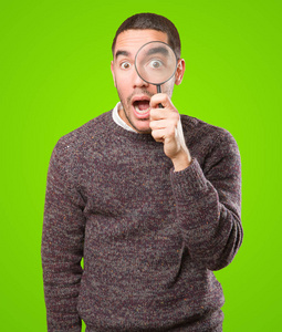 担心的年轻人惊讶惊讶的年轻人使用放大镜照片