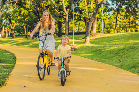 母亲和儿子骑自行车户外和微笑图片