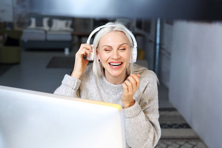 在线音乐, 互联网收音机。一个戴着耳机的女人在电脑上工作