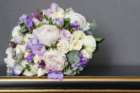 新娘结婚花束与牡丹, 小苍兰和其他花在黑桌上。淡紫色的春天的颜色。早晨在房间里