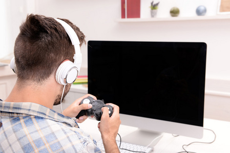 年轻人在家里玩电脑游戏照片