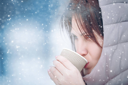 美丽的女孩在冬天喝一杯热饮, 在自然界, 茶, 咖啡。户外雪