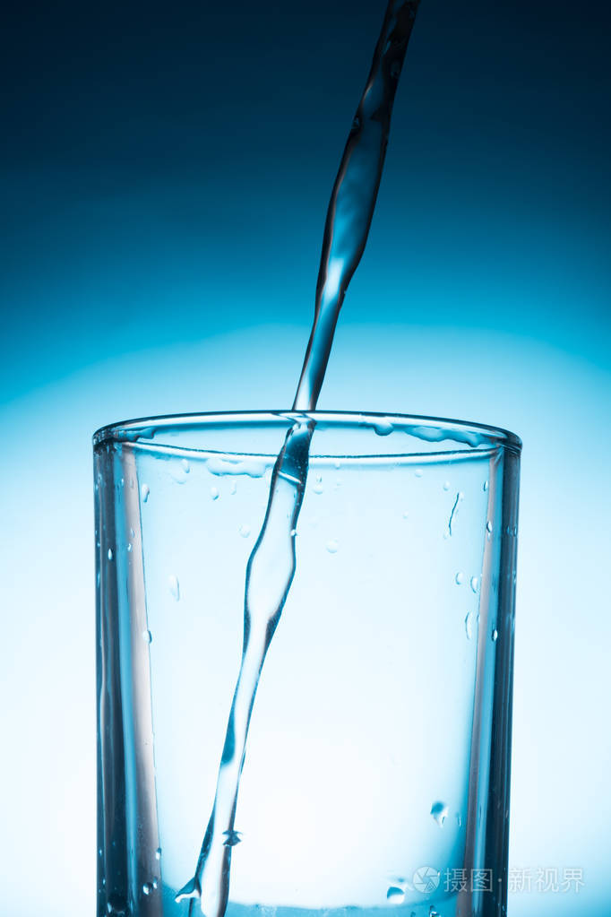 倒水入杯在蓝色背景