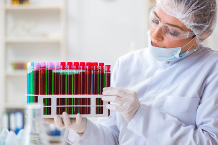 医生和护士持有血液试管血液由护士在医院里,验血检查收集并捐出概念