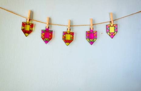 形象的犹太节日光明节与彩色玻璃七彩陀螺 陀螺 挂在一根绳子在木制的