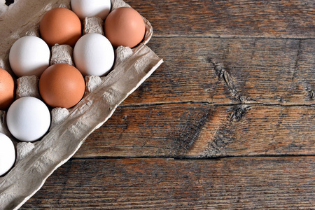 在一个简陋的木桌上, 一张纸蛋纸盒里的农场新鲜有机鸡蛋的特写图像