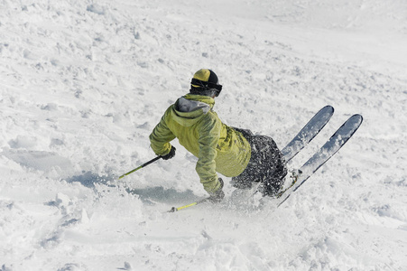 男随心所欲滑雪者的背观滑下雪山