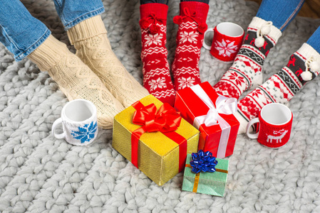 在针织的袜子和圣诞礼物的腿