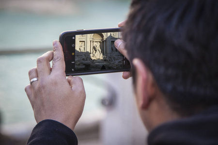 游客拍摄与智能手机在罗马特雷维喷泉