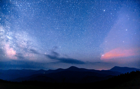 深邃的天空 astrophoto。梦幻般的冬天流星雨和白雪皑皑的山峦