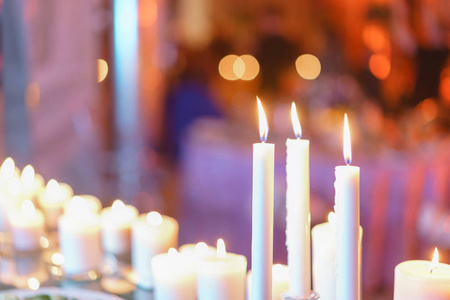 燃烧的蜡烛。在餐厅的豪华婚宴上, 玻璃烛台上的白色蜡烛站在桌上。时尚的装饰和装饰