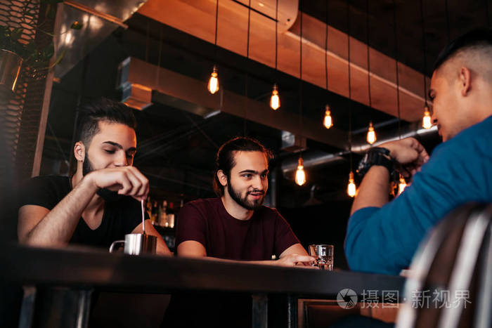 多种族的朋友在咖啡馆玩得开心.男人聚会