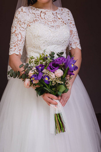 新娘的花束在结婚戒指的手中。新娘捧着一束花束