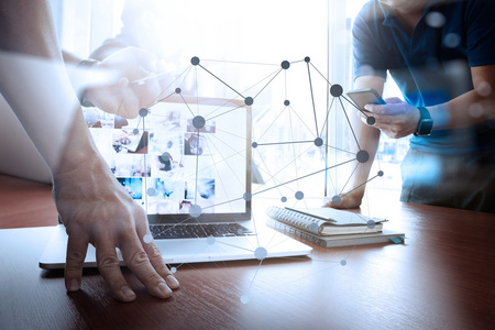 设计师的手工作和智能手机和笔记本电脑在木桌上照片