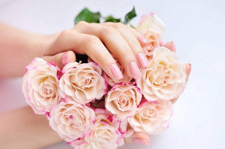 粉红玫瑰白色背景与一个女人的手