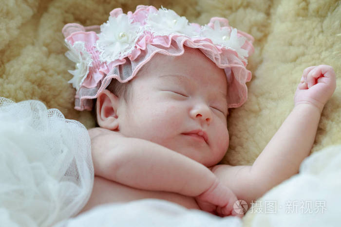 刚出生的婴儿的女孩睡在毛皮毯子上照片