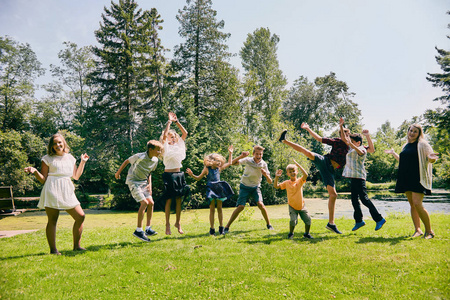 快乐的儿童跳或跳舞在夏季公园