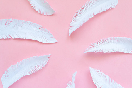 羽毛由白色纸在粉红色背景的鸟制成照片