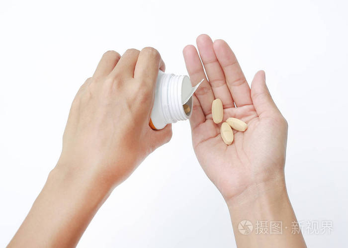 白色背景的手捧黄色药丸