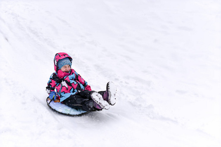 一个滑雪小女孩在山上反对冬天风景