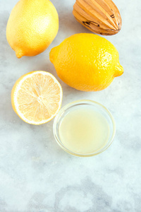 新鲜柠檬汁在小碗和柠檬在土气白色石头背景与拷贝空间健康成分为烹调和烘烤