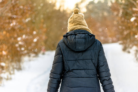 妇女在冬天雪, 女孩在黑夹克在公园, 后面看法