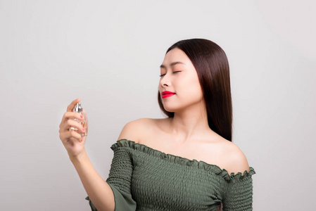 年轻漂亮的女人控股瓶的香水,闻着香味照片