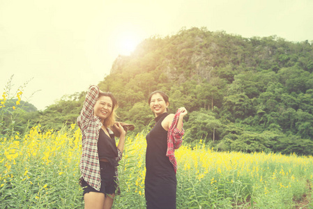 两个时髦的女人旅行和享受花卉领域忘记