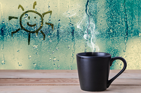 黑咖啡杯子上水滴的烟雾和太阳标志与玻璃无线
