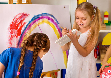 儿童绘画手指放在画架上。群与老师的孩子