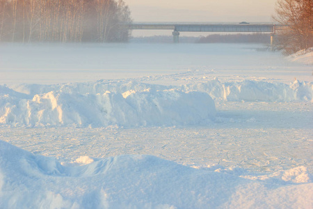 孩子们在冰冻的溜冰场一座桥和一个冬雾