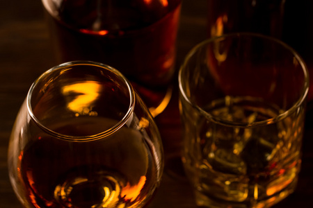 杯加冰和木制的桌子上一瓶威士忌。科涅克白兰地白兰地