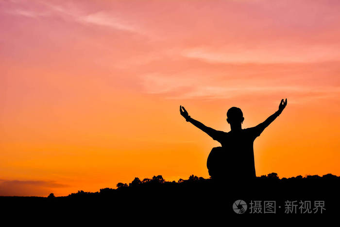 男人用背包张开的手上天空日落的剪影