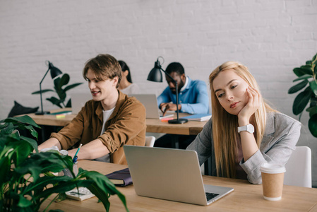 多文化商务同事坐在桌前, 在现代办公室里工作笔记本电脑照片