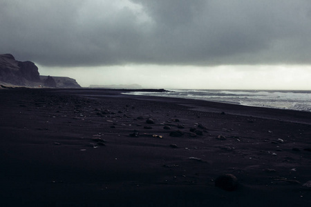 用黑色的沙子和石子的海滨