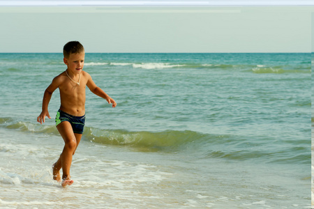 小男孩在海上夏季运行海滩